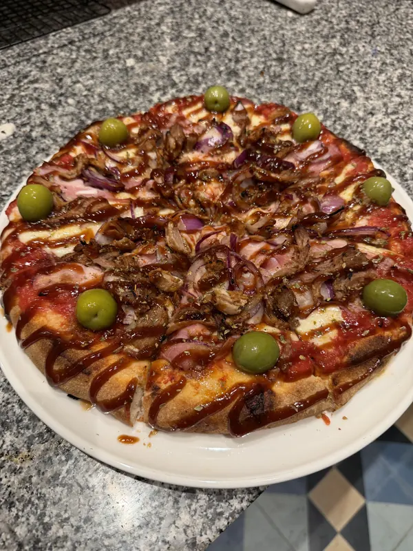 Pizza argentina de pulled pork con salsa BBQ, cebolla morada y aceitunas verdes de Malandra Balmes, Palma