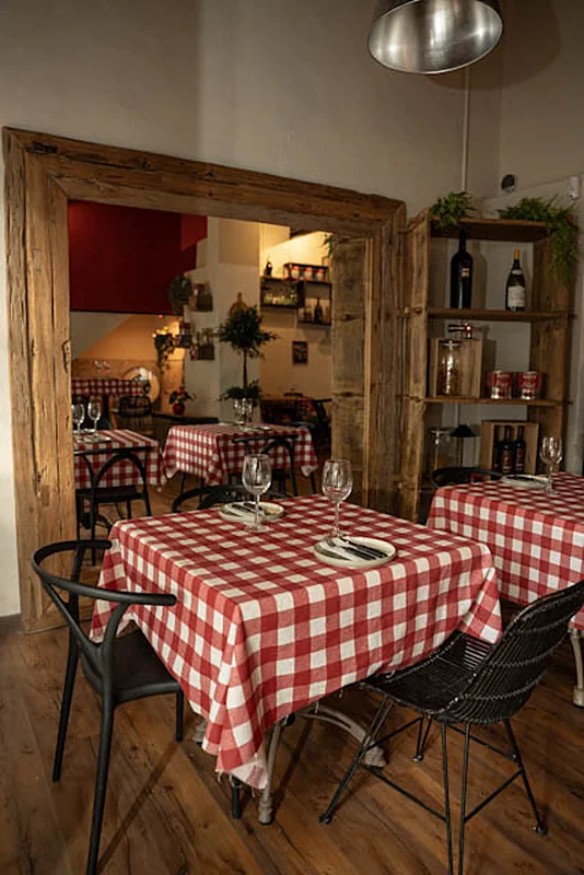 Mesas con mantel a cuadros rojo y blanco en la sala de Malandra Santa Catalina, Palma